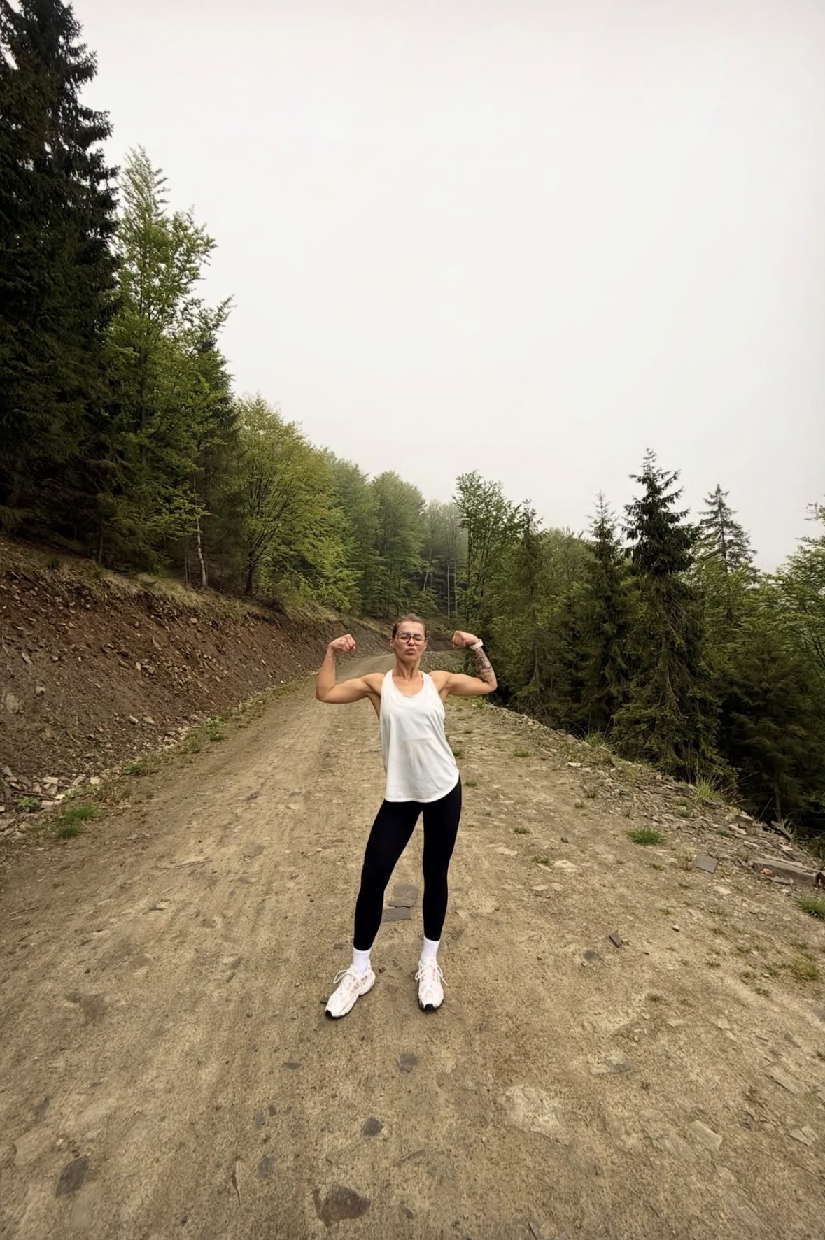 Wiktoria Głowacka flexing her biceps after a training run on a forest trail